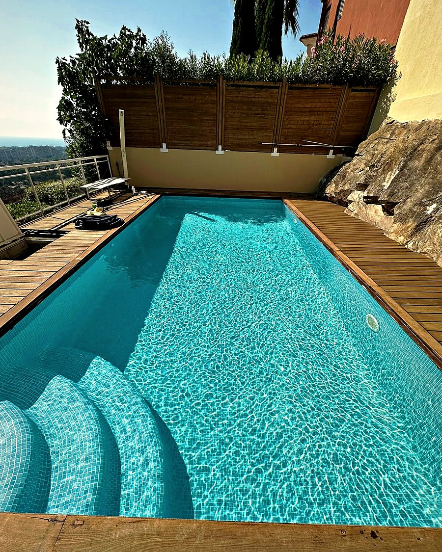 Piscine avec terrasse en bois et vue sur la mer